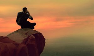 man sitting alone on mountain