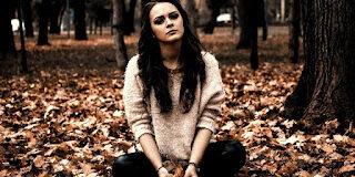 Girl-sitting-alone-in-the-leaves