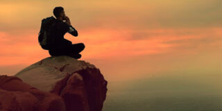 man sitting alone on mounain